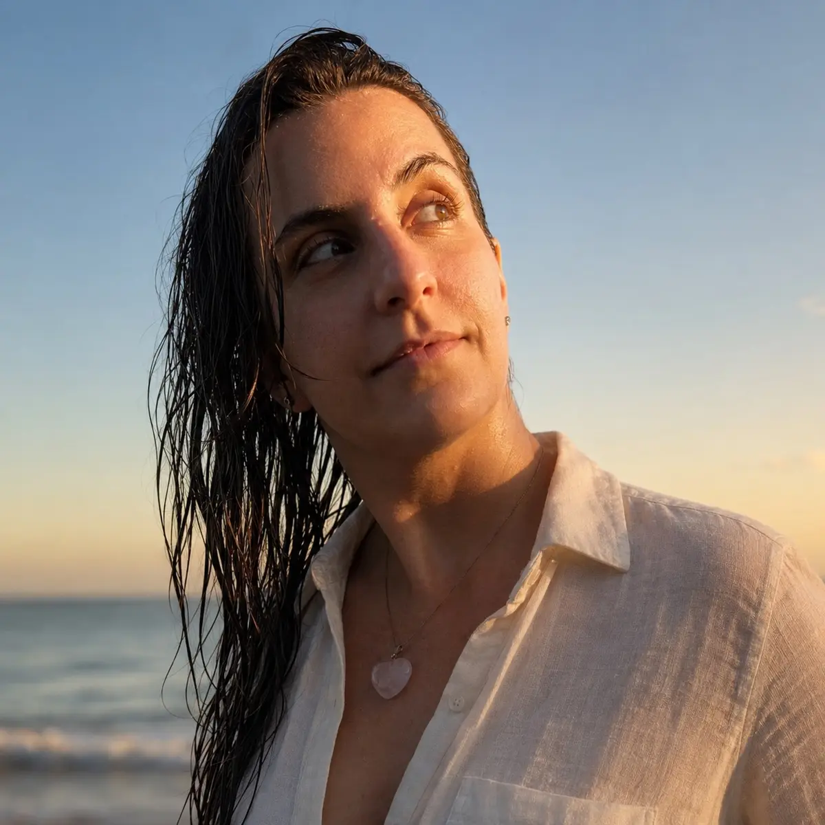 Aline Mezzalira à beira-mar ao pôr do sol